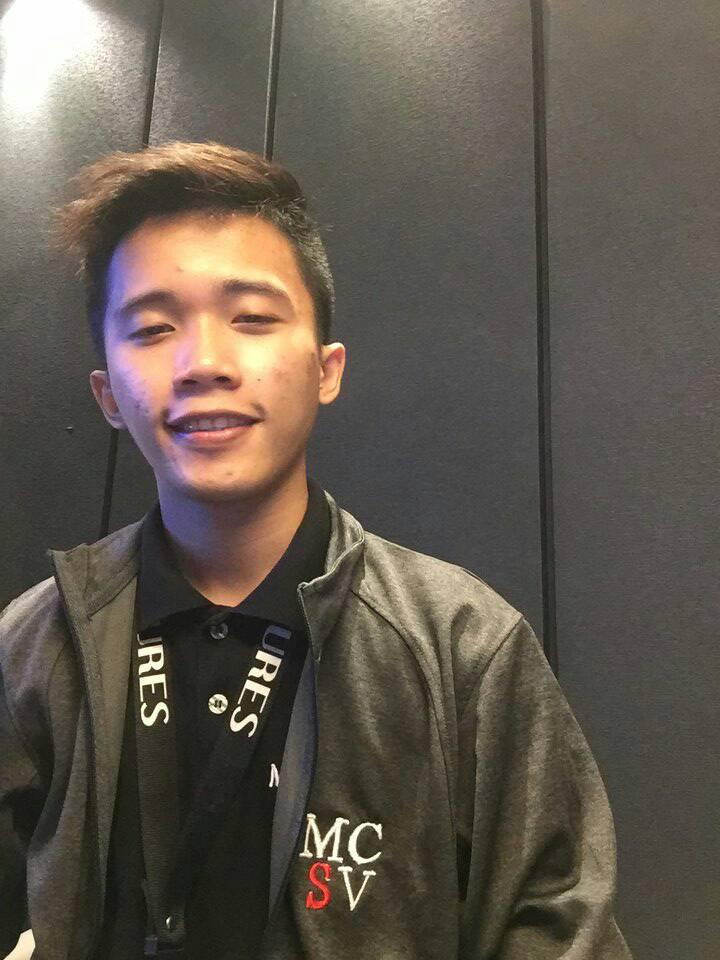 Professional headshot of Xander Rosanto, a software engineer with short dark hair, wearing a casual shirt, smiling confidently in a modern office setting with coding backgrounds